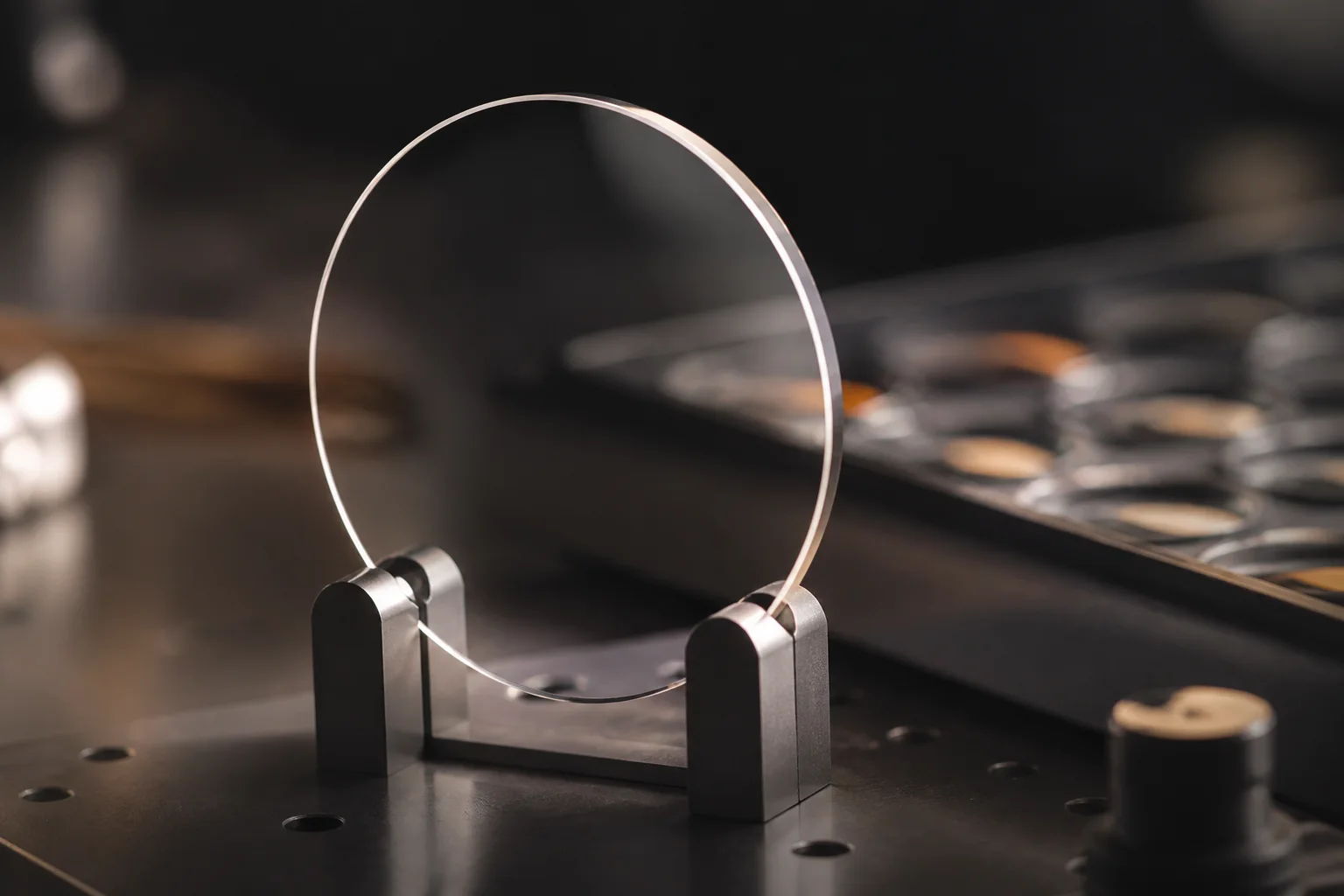 Clear prescription lens blank held upright on an optical workbench